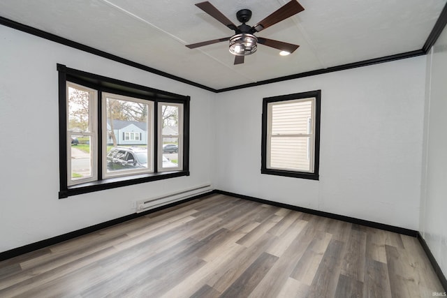 empty room featuring ceiling fan, crown molding, wood finished floors, baseboards, and a baseboard heating unit
