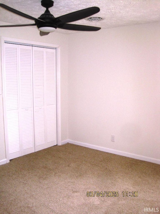 unfurnished bedroom featuring ceiling fan, visible vents, baseboards, a closet, and carpet