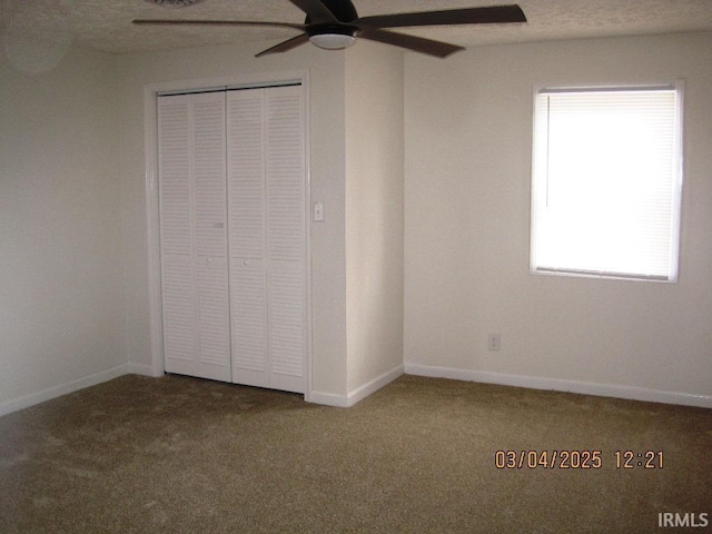 unfurnished bedroom featuring a ceiling fan, baseboards, carpet, and a closet