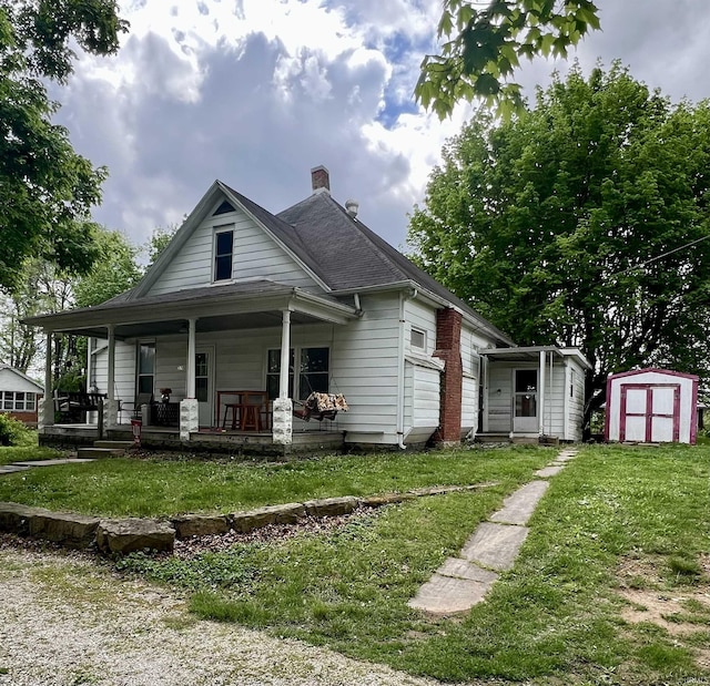 bungalow-style home featuring a storage shed, a front yard, a chimney, and a porch