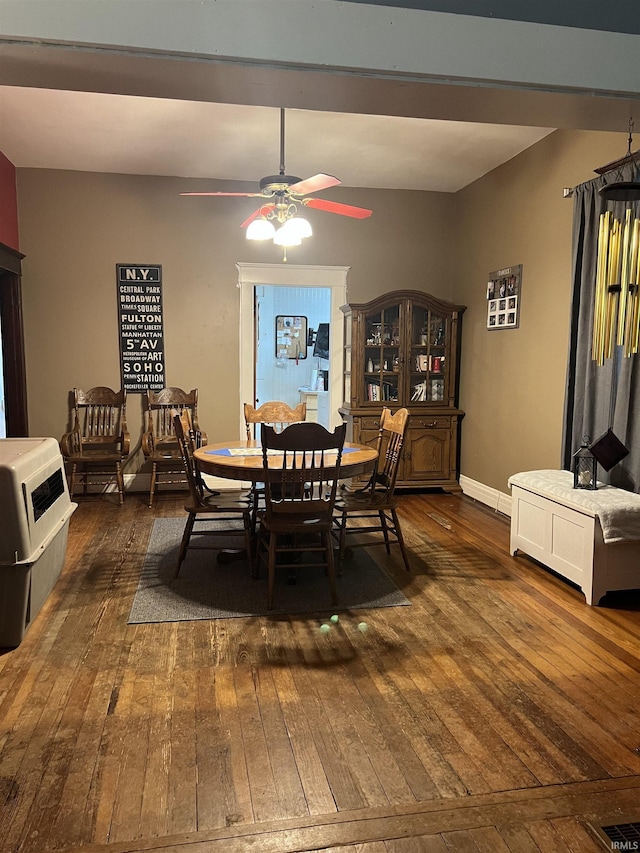 dining room with baseboards, a ceiling fan, dark wood finished floors, and heating unit