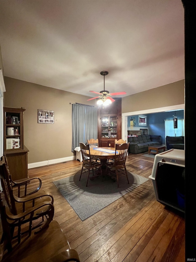 dining area featuring wood-type flooring, ceiling fan, and baseboards