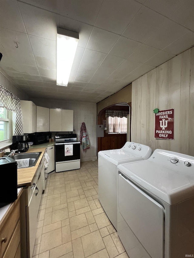 washroom with laundry area, washer and clothes dryer, a sink, and a wealth of natural light