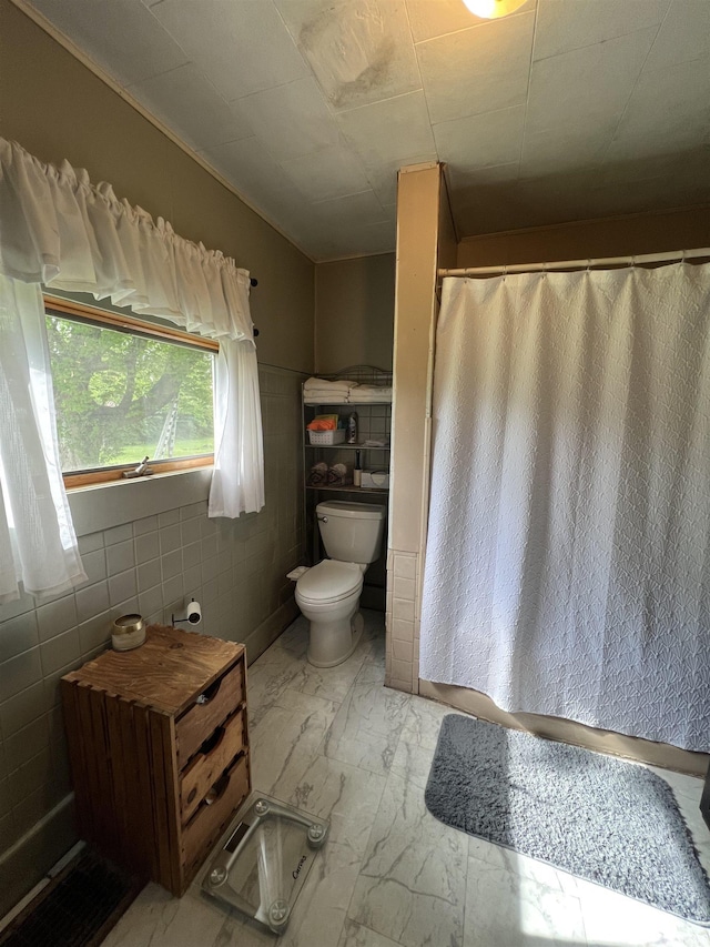 full bathroom featuring tile walls, a shower with curtain, toilet, and marble finish floor