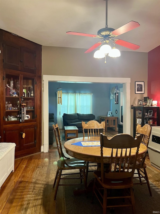 dining area featuring dark wood-style flooring and ceiling fan