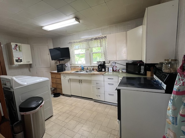 kitchen featuring washer / clothes dryer, black microwave, light countertops, a sink, and white range with electric stovetop