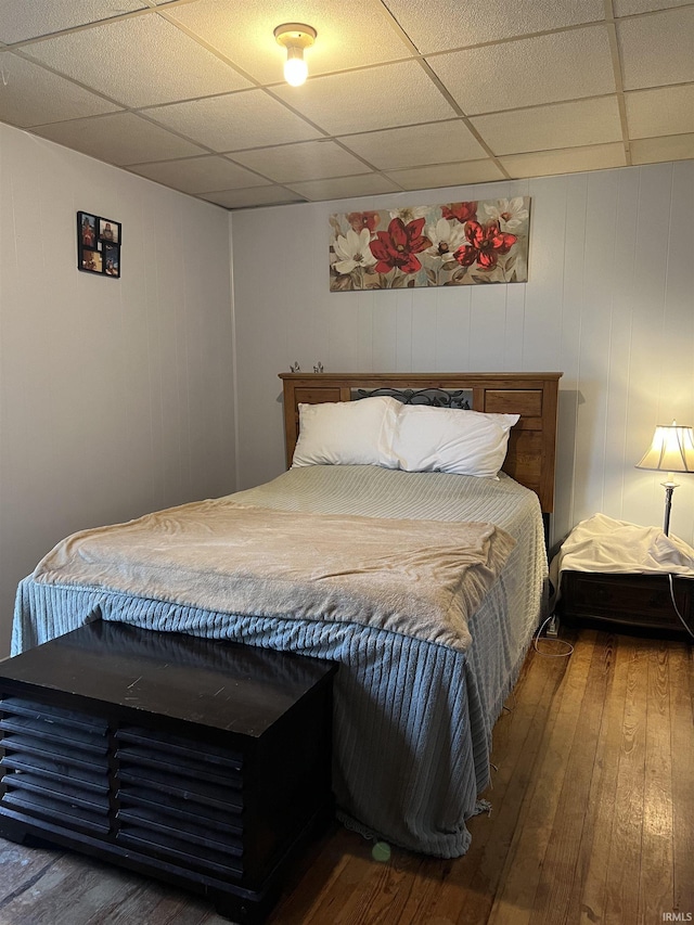 bedroom featuring wood-type flooring and a paneled ceiling