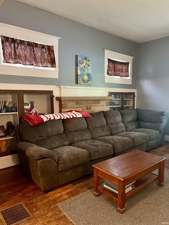 living area with visible vents and wood finished floors