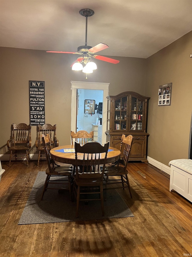dining area featuring baseboards, a ceiling fan, and dark wood-style flooring