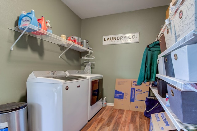 laundry room featuring separate washer and dryer, laundry area, and wood finished floors
