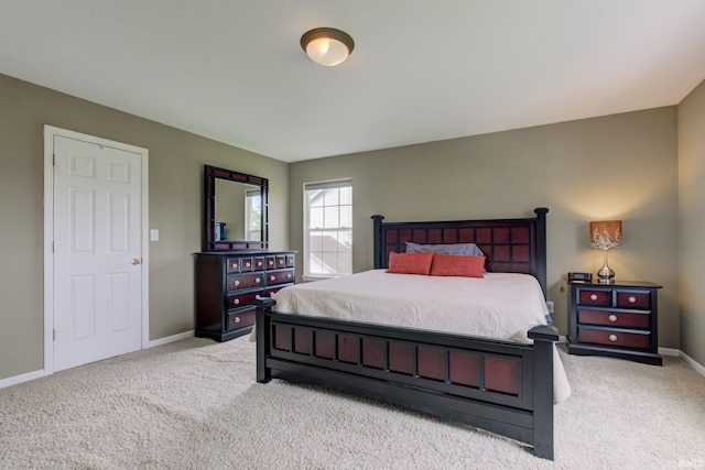 bedroom featuring light colored carpet and baseboards