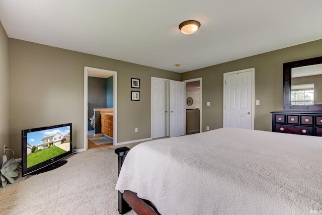 carpeted bedroom with baseboards and ensuite bath