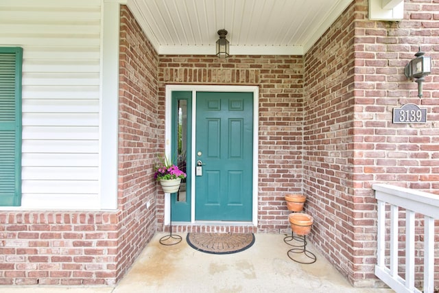 entrance to property featuring brick siding