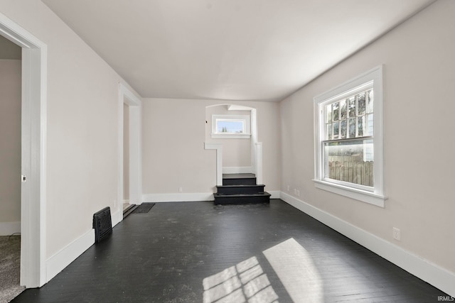 interior space with baseboards, dark wood-style flooring, a wealth of natural light, and stairway