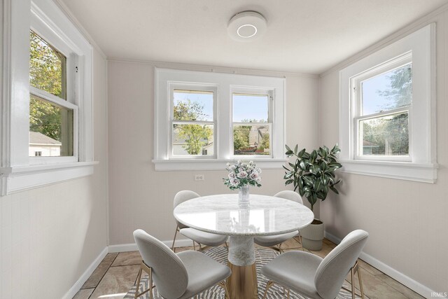 dining room featuring baseboards, light tile patterned floors, and a wealth of natural light