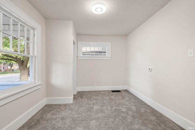 unfurnished room featuring carpet floors, baseboards, and visible vents