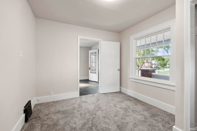 spare room featuring carpet floors and baseboards