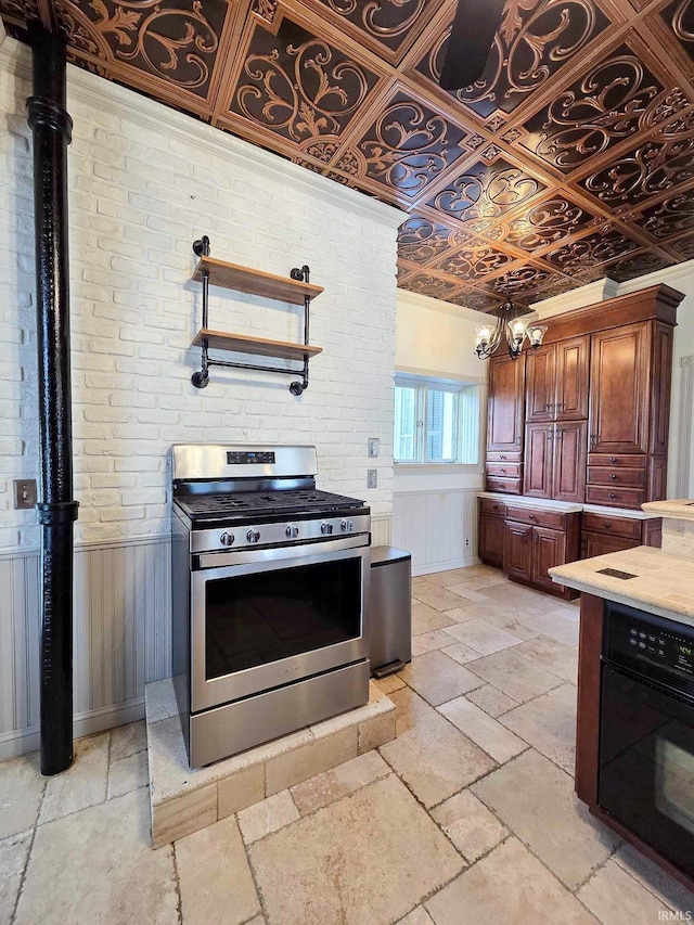 1106 E 5th St, Fowler, IN 47944 - kitchen with oven, wainscoting, light countertops, stone tile floors, and gas range