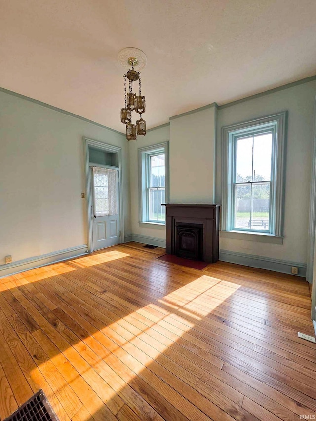 1106 E 5th St, Fowler, IN 47944 - unfurnished living room featuring baseboards, a notable chandelier, and hardwood / wood-style flooring