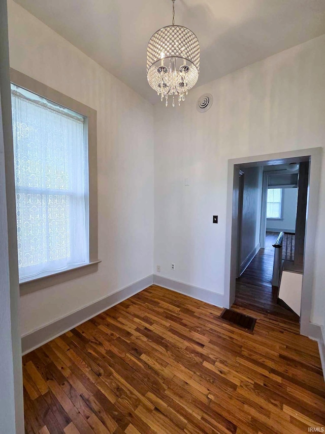 1106 E 5th St, Fowler, IN 47944 - unfurnished room featuring baseboards, visible vents, a notable chandelier, and dark wood-type flooring