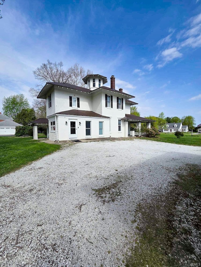 1106 E 5th St, Fowler, IN 47944 - view of home's exterior with a yard, stucco siding, driveway, and a chimney