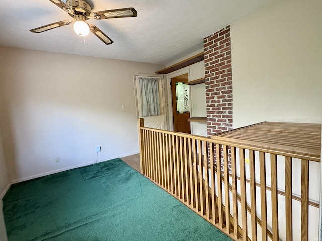 carpeted empty room featuring ceiling fan and baseboards