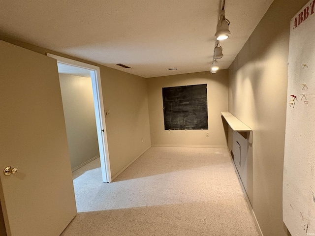 interior space with baseboards, rail lighting, and visible vents
