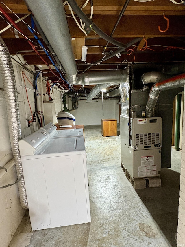 unfinished basement featuring washer and clothes dryer and heating unit