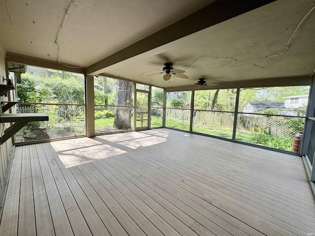 unfurnished sunroom featuring a ceiling fan