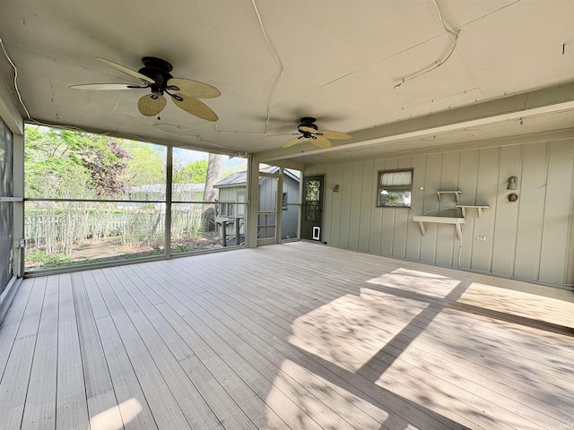 wooden terrace with an outbuilding, ceiling fan, and a storage shed