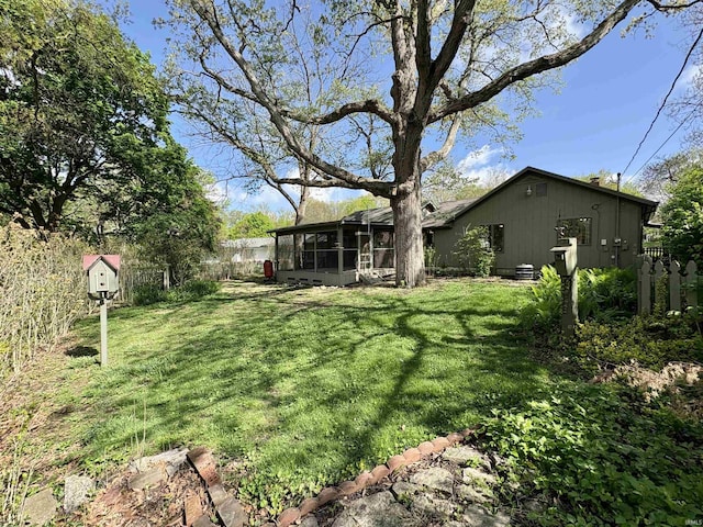 view of yard featuring fence and a sunroom