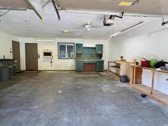 garage featuring ceiling fan, heating unit, a workshop area, and a garage door opener