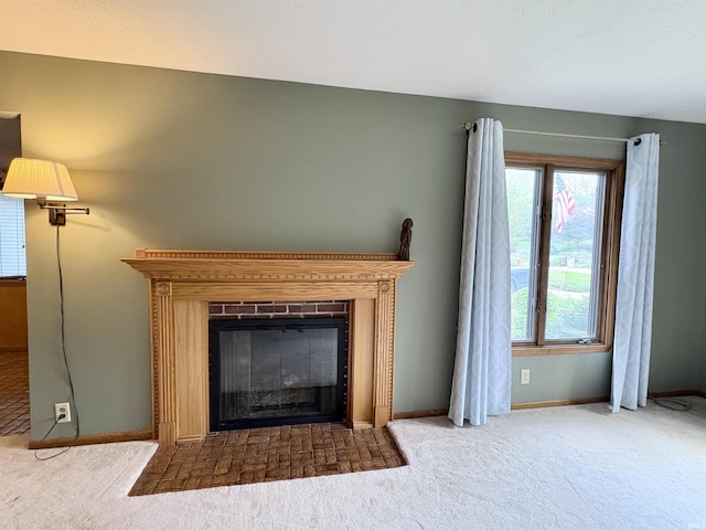interior details with carpet floors, baseboards, and a glass covered fireplace