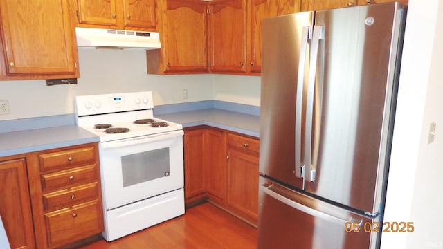 4214 Hunters Trce, Evansville, IN 47715 - kitchen with freestanding refrigerator, wood finished floors, light countertops, under cabinet range hood, and electric stove