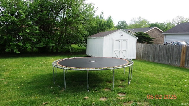 4214 Hunters Trce, Evansville, IN 47715 - view of yard with a storage unit, a trampoline, fence, and an outbuilding