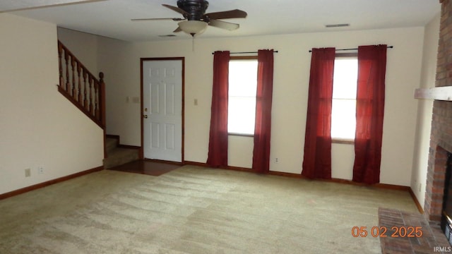 4214 Hunters Trce, Evansville, IN 47715 - unfurnished living room with visible vents, stairs, a fireplace, ceiling fan, and carpet