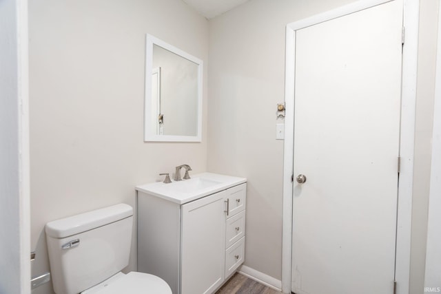 bathroom with vanity, toilet, and wood finished floors
