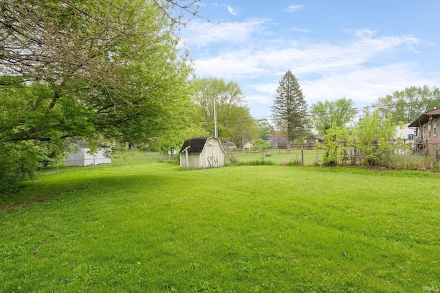 view of yard with a storage shed, fence, and an outdoor structure