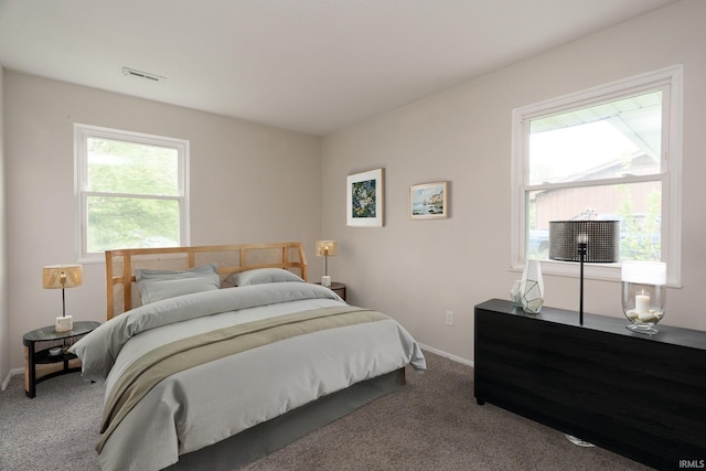carpeted bedroom featuring baseboards and visible vents