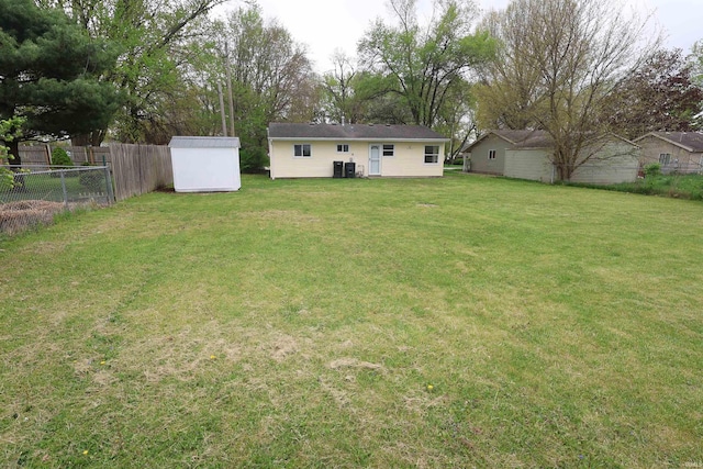 1421 E Ireland Rd, South Bend, IN 46614 - view of yard with an outdoor structure, central AC unit, fence, and a storage shed