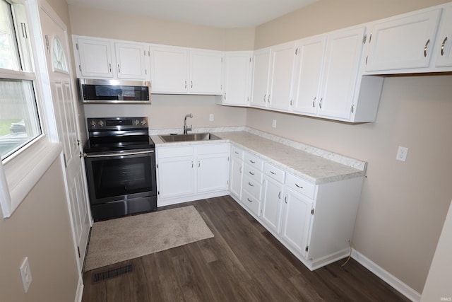 1421 E Ireland Rd, South Bend, IN 46614 - kitchen featuring dark wood-style flooring, appliances with stainless steel finishes, white cabinetry, and visible vents