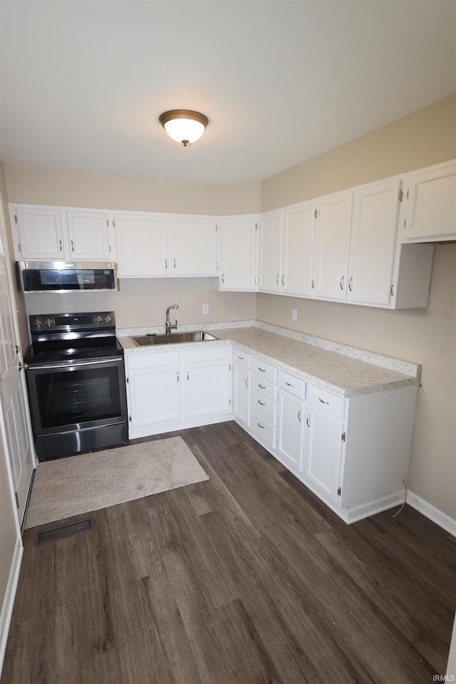 1421 E Ireland Rd, South Bend, IN 46614 - kitchen featuring a sink, white cabinets, stainless steel appliances, and dark wood-style floors