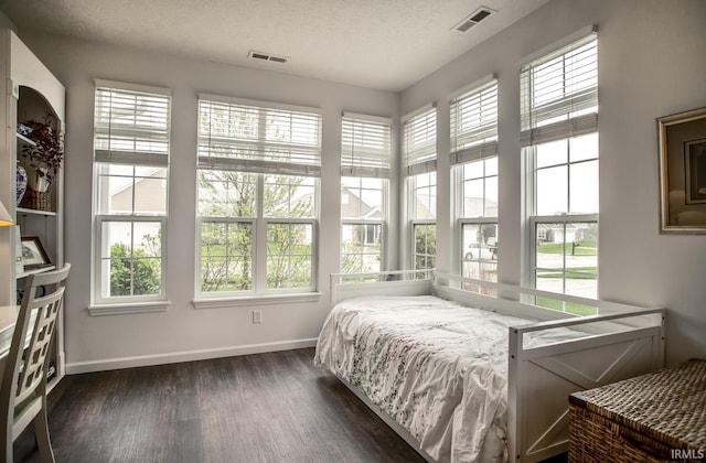 bedroom with visible vents, a textured ceiling, baseboards, and dark wood-type flooring