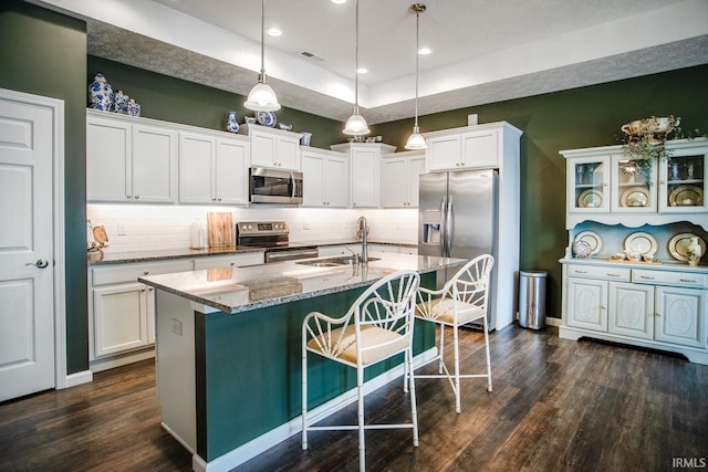 kitchen featuring decorative backsplash, visible vents, appliances with stainless steel finishes, dark wood finished floors, and a sink