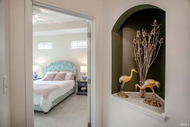 carpeted bedroom featuring arched walkways