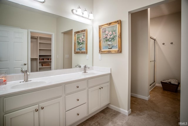 full bathroom featuring double vanity, a sink, and a stall shower
