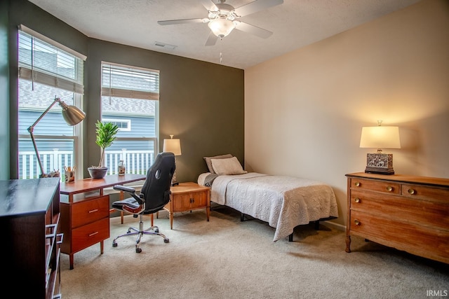 bedroom featuring light colored carpet, ceiling fan, and visible vents