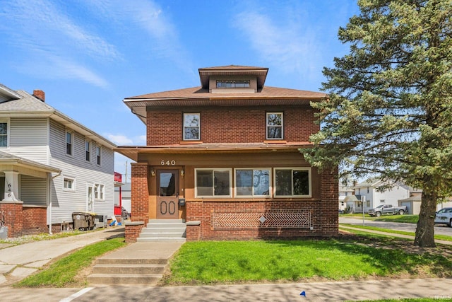 traditional style home featuring brick siding and a front lawn