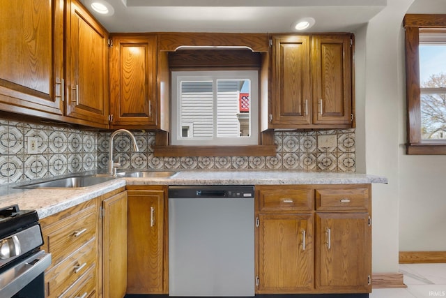 kitchen featuring light countertops, brown cabinets, gas stove, and dishwasher