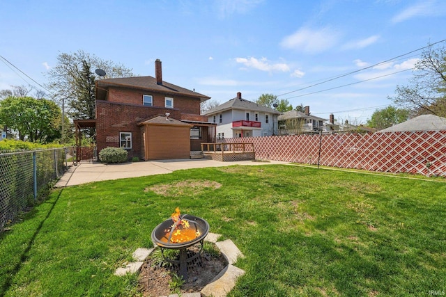 view of yard with a fire pit, a fenced backyard, and a patio area